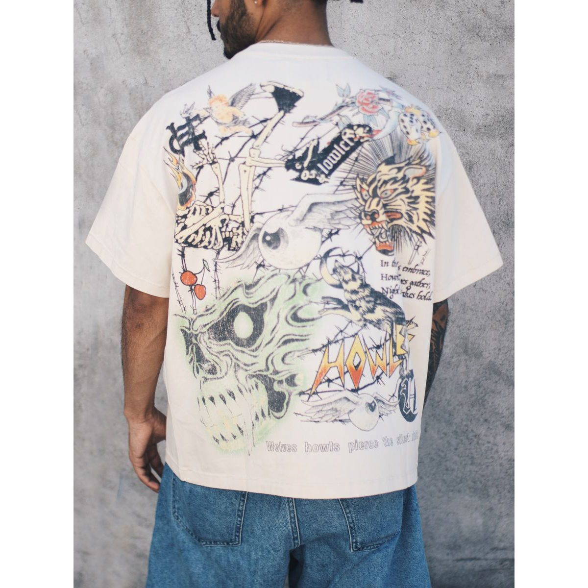 Howlers Club Magic Wolf Graphic Tee featuring all-over skull, skeleton, and flame graphics on cream streetwear shirt