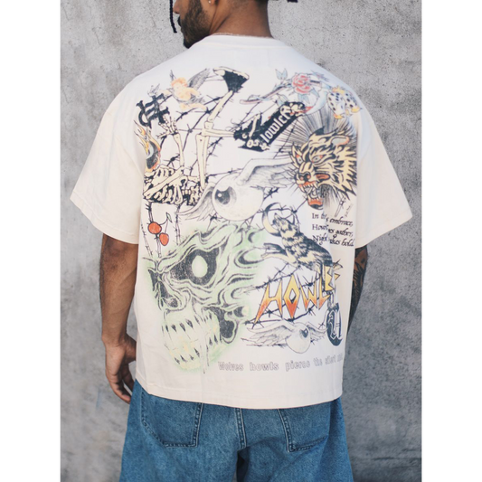 Howlers Club Magic Wolf Graphic Tee featuring all-over skull, skeleton, and flame graphics on cream streetwear shirt